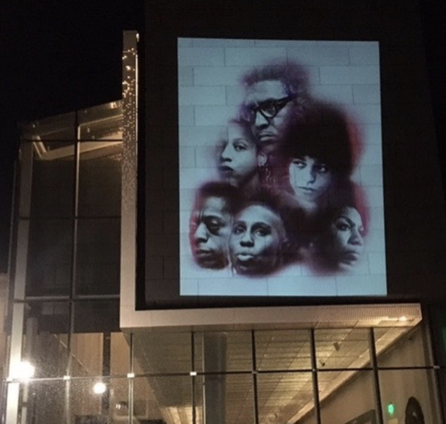 The faces of Black Queer artists projected onto the Asheville Art Museum in Downtown Asheville